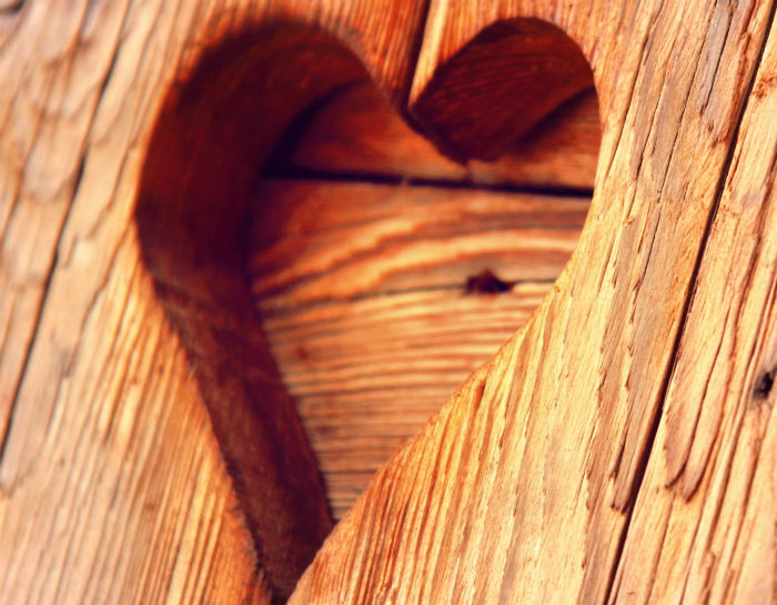heart shaped carving into wood surface of furniture
